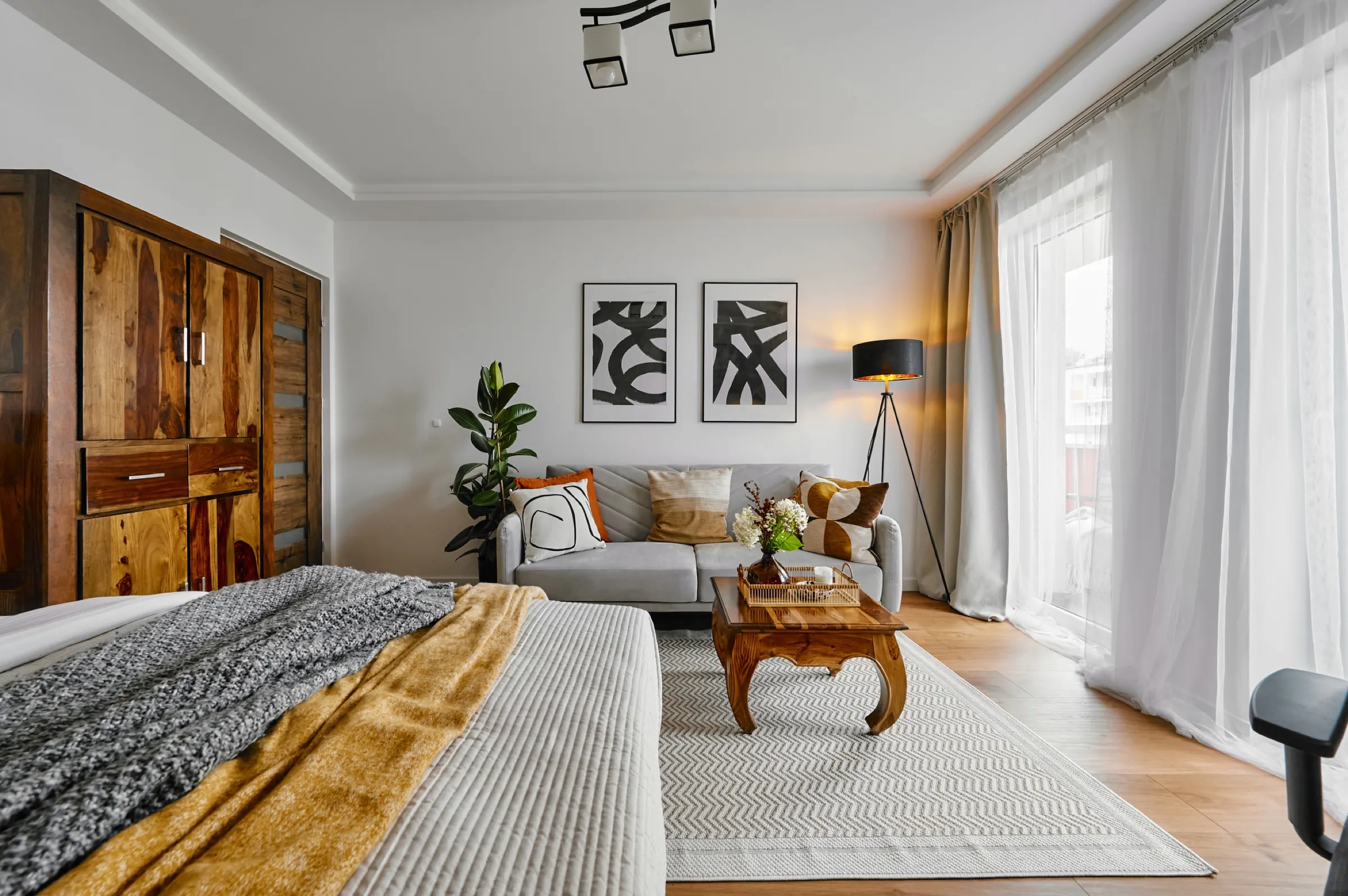 Bedroom with the living area behind it and wooden furniture