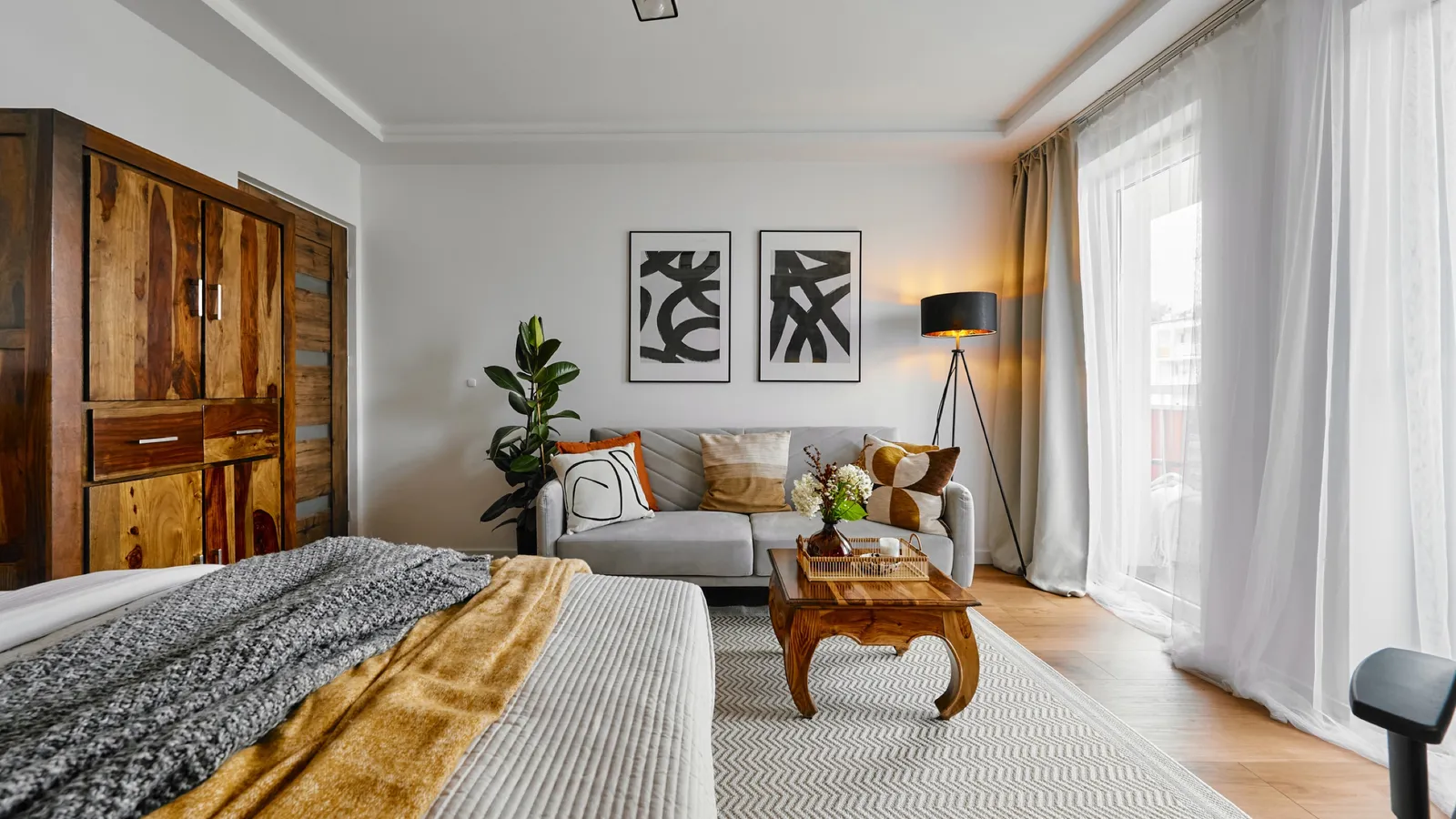 Bedroom with the living area behind it and wooden furniture