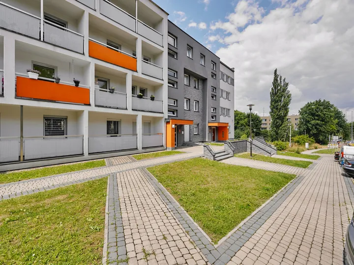 The building with orange balconies and lawns