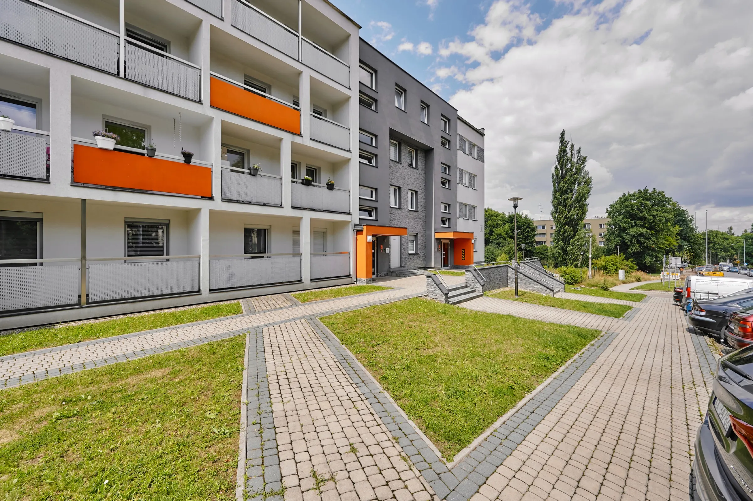 The building with orange balconies and lawns