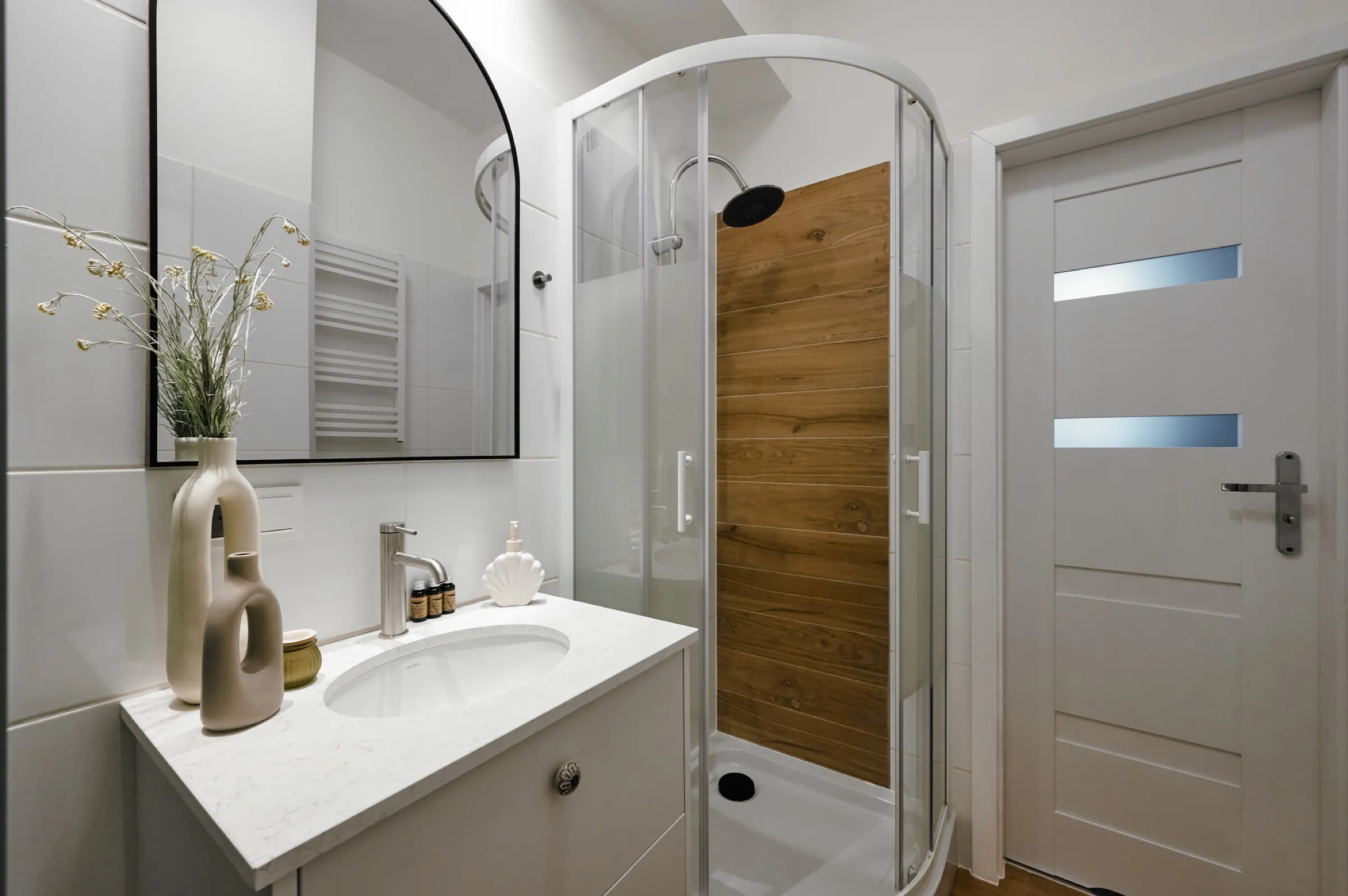 Bathroom with shower and an arched mirror