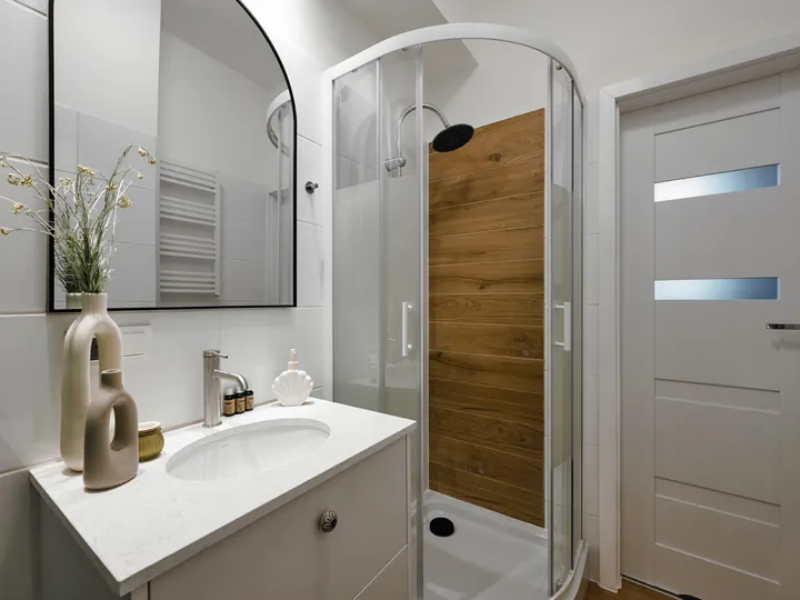 Bathroom with shower and an arched mirror