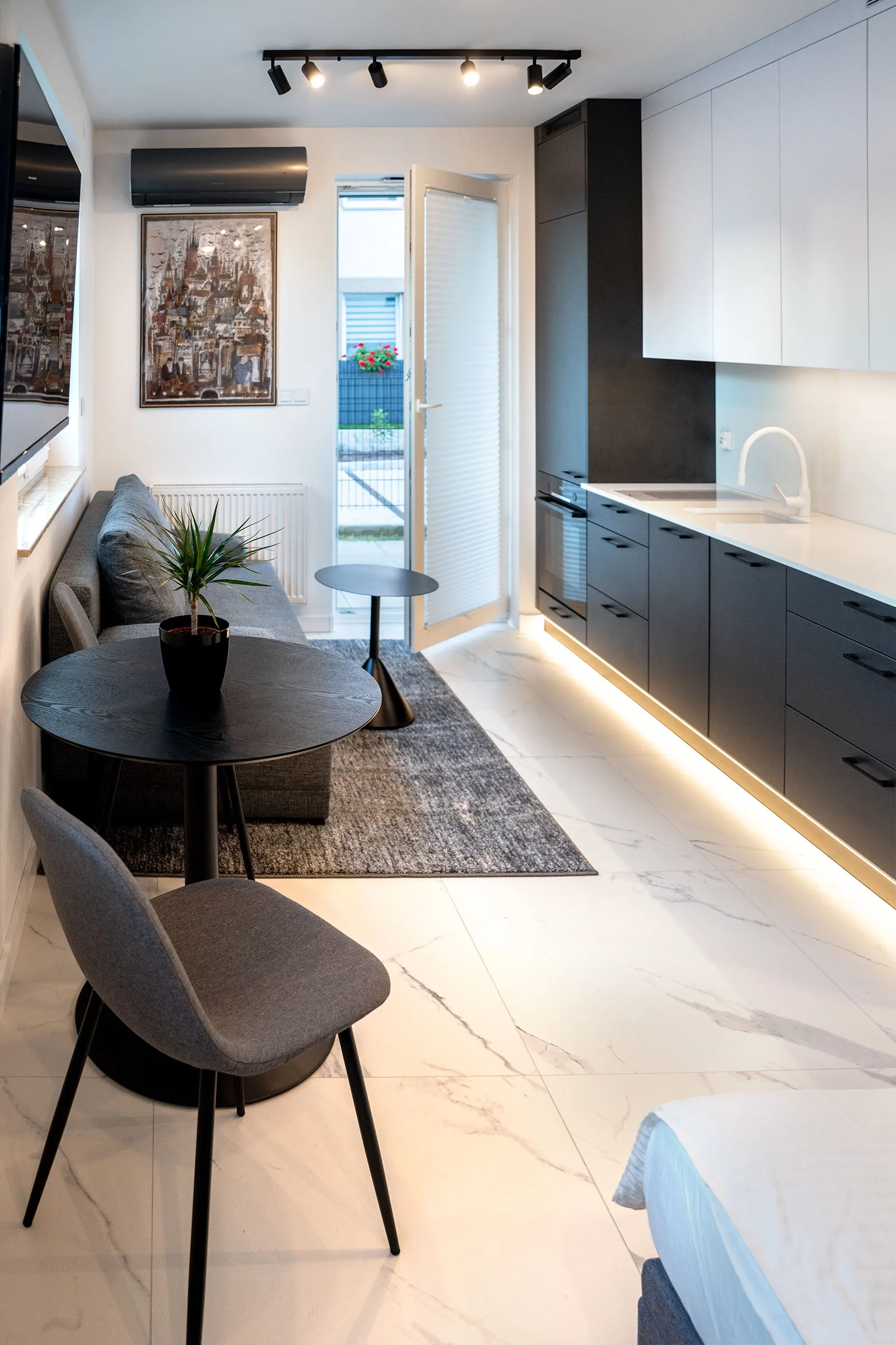 View along the apartment with the lit kitchen units